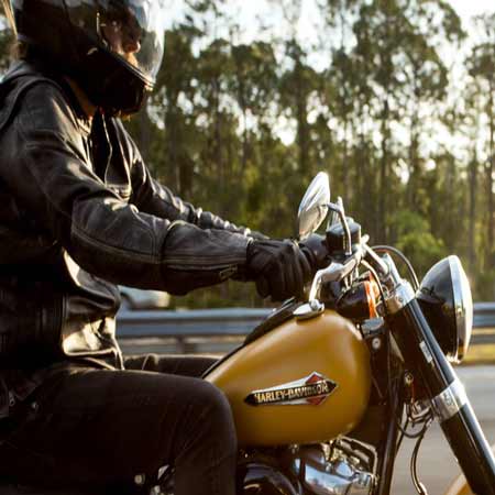 Guy riding motorcycle with apparel and safety gear