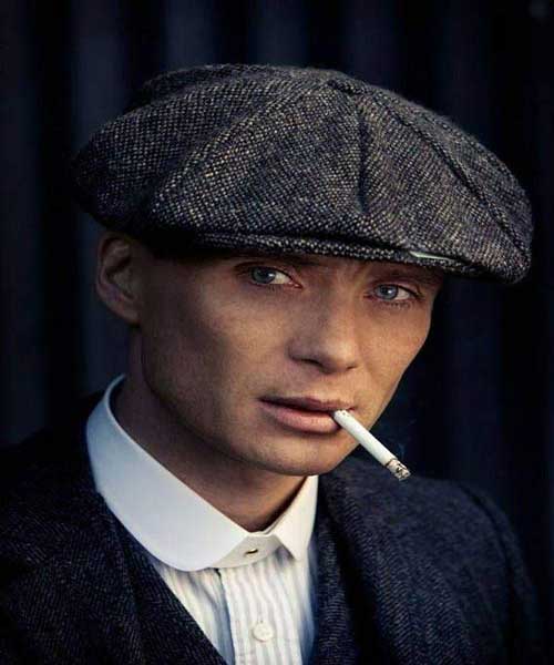 Thomas Shelby wearing a peaked flat cap